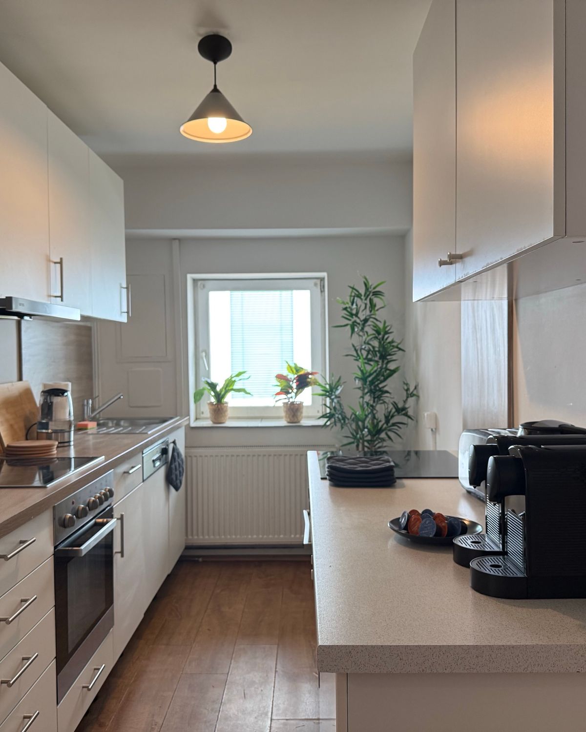 Voll ausgestattete Küche mit Backofen und Kaffeemaschine in einem MA-Flats Apartment