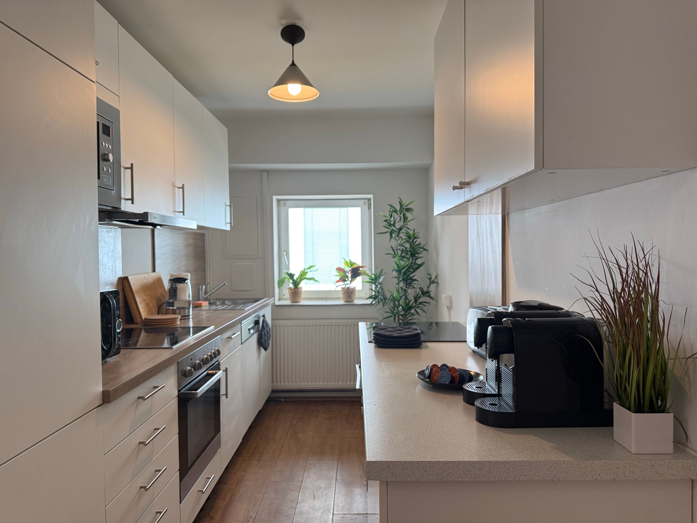 Voll ausgestattete Küche mit Backofen und Kaffeemaschine in einem MA-Flats Apartment