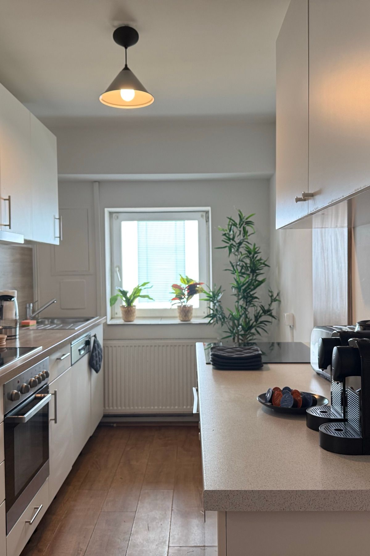 Voll ausgestattete Küche mit Backofen und Kaffeemaschine in einem MA-Flats Apartment