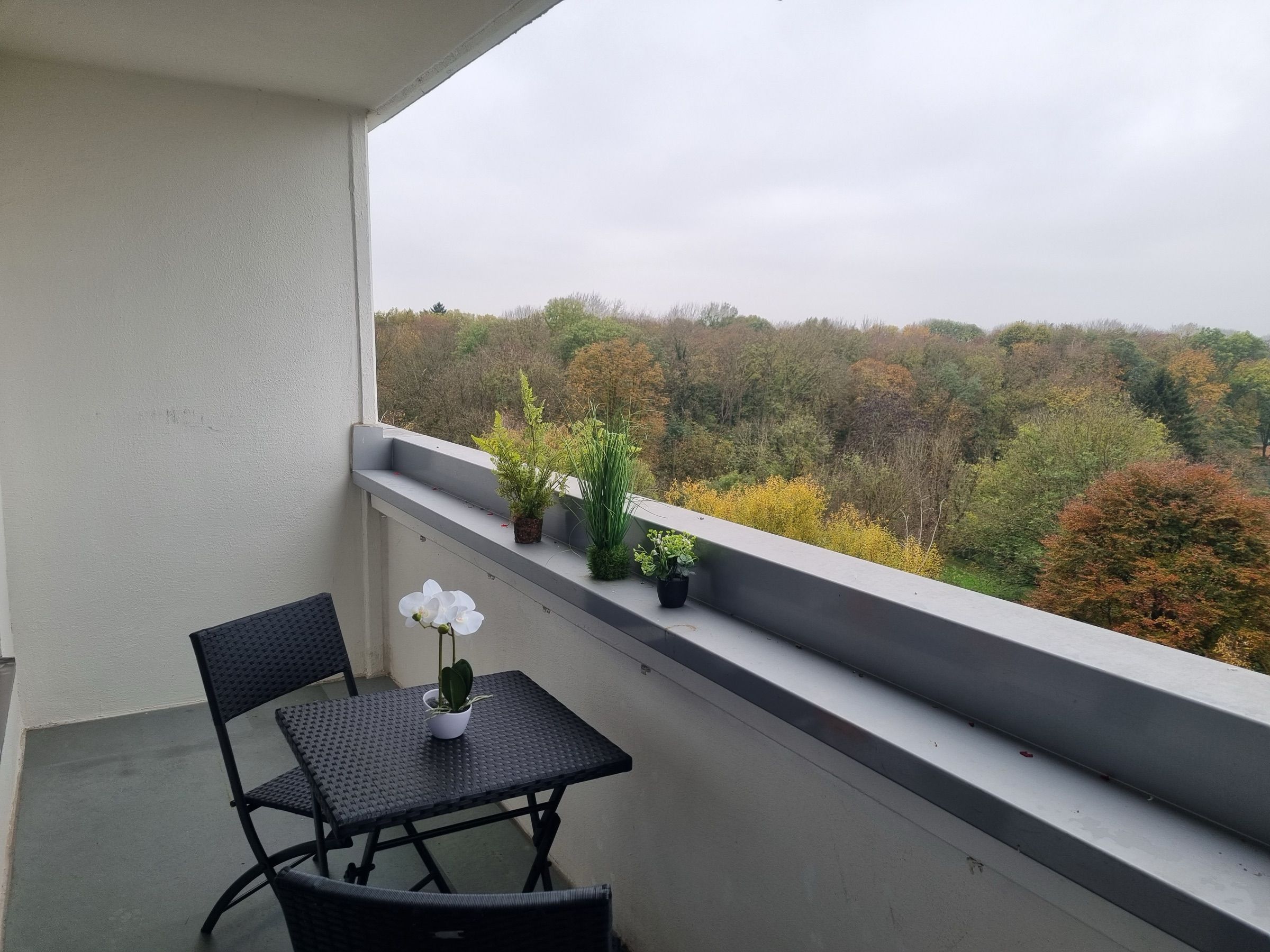 Namešten balkon sa stolom i pogledom na zelenilo uz MA-Flats stan