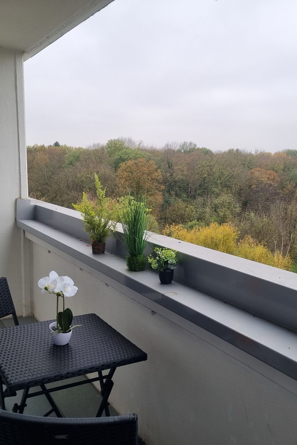 Namešten balkon sa stolom i pogledom na zelenilo uz MA-Flats stan