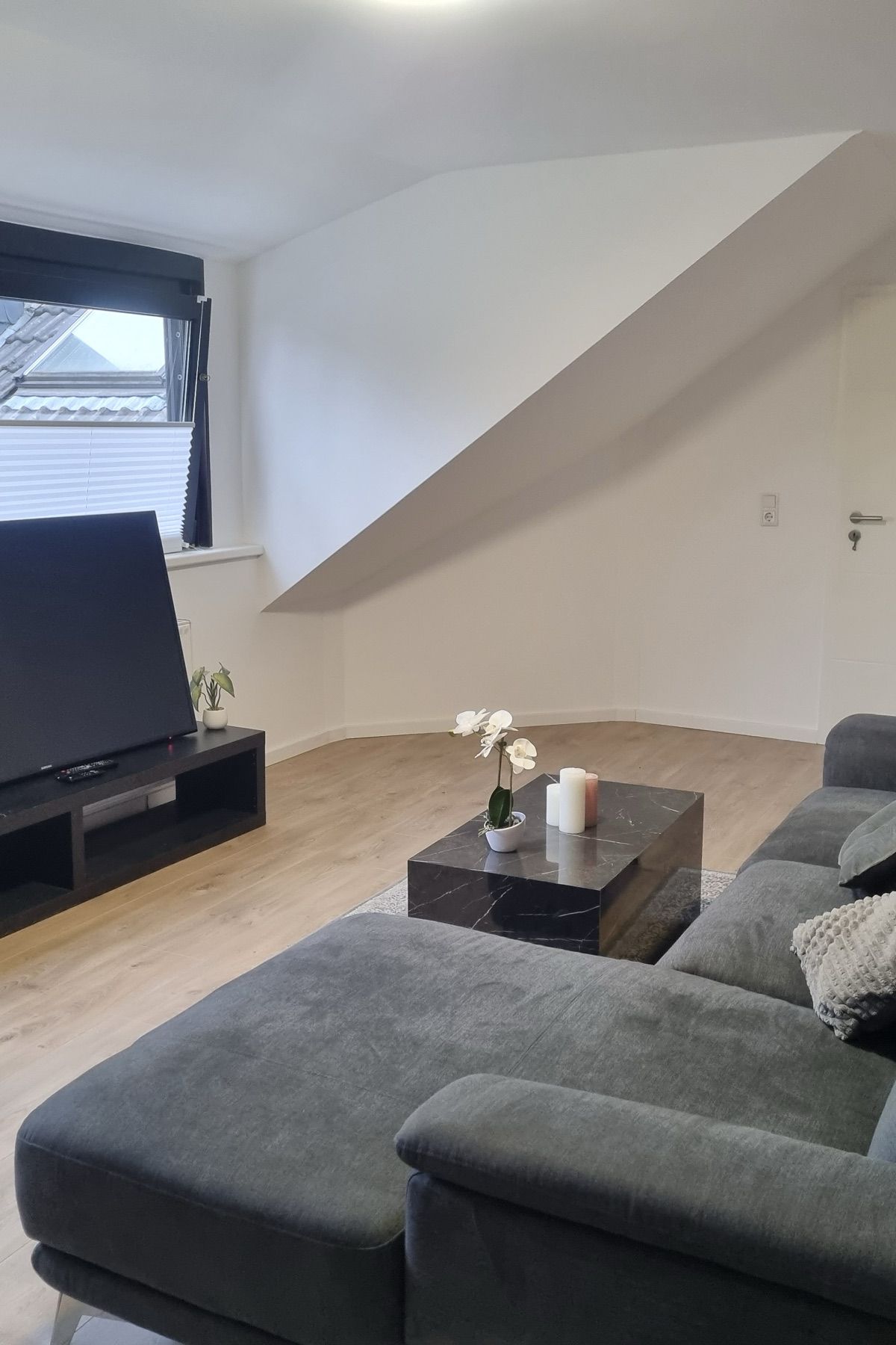 Wohnzimmer mit großem Ecksofa und Fernseher in einem möblierten MA-Flats Apartment