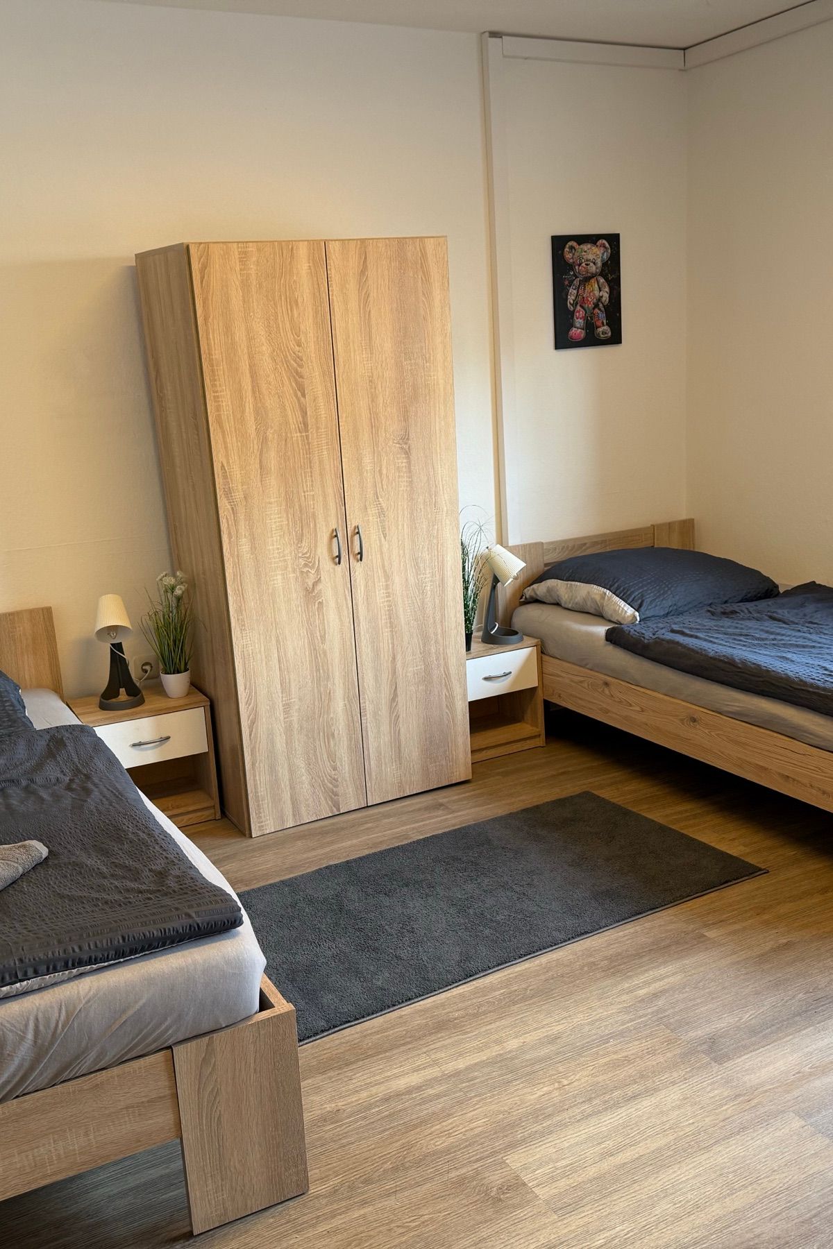 Dvokrevetna soba sa ormanom i sveže pospremljenim krevetima u MA-Flats stanu