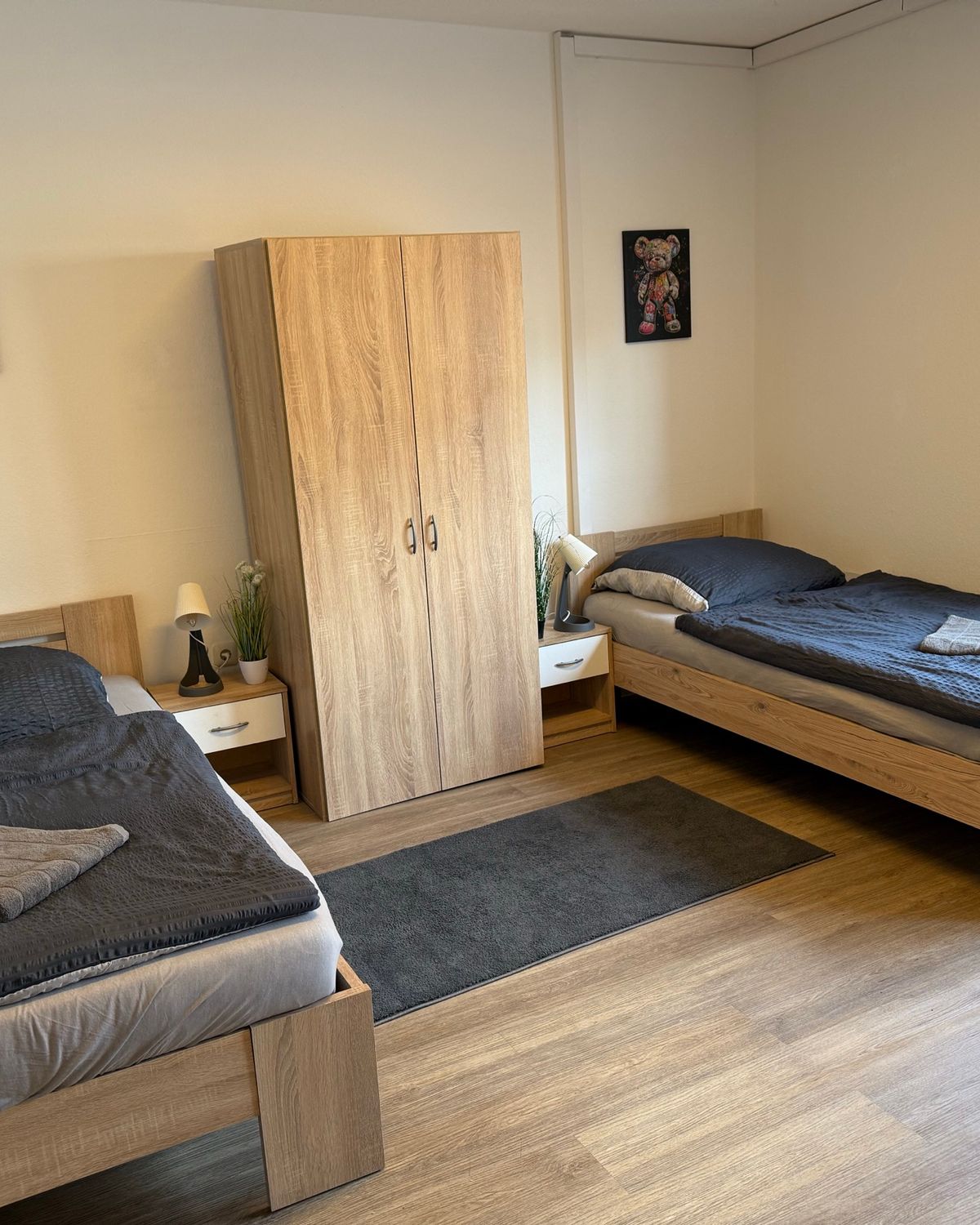 Zweibettzimmer mit Kleiderschrank und frisch bezogenen Betten in einem MA-Flats Apartment