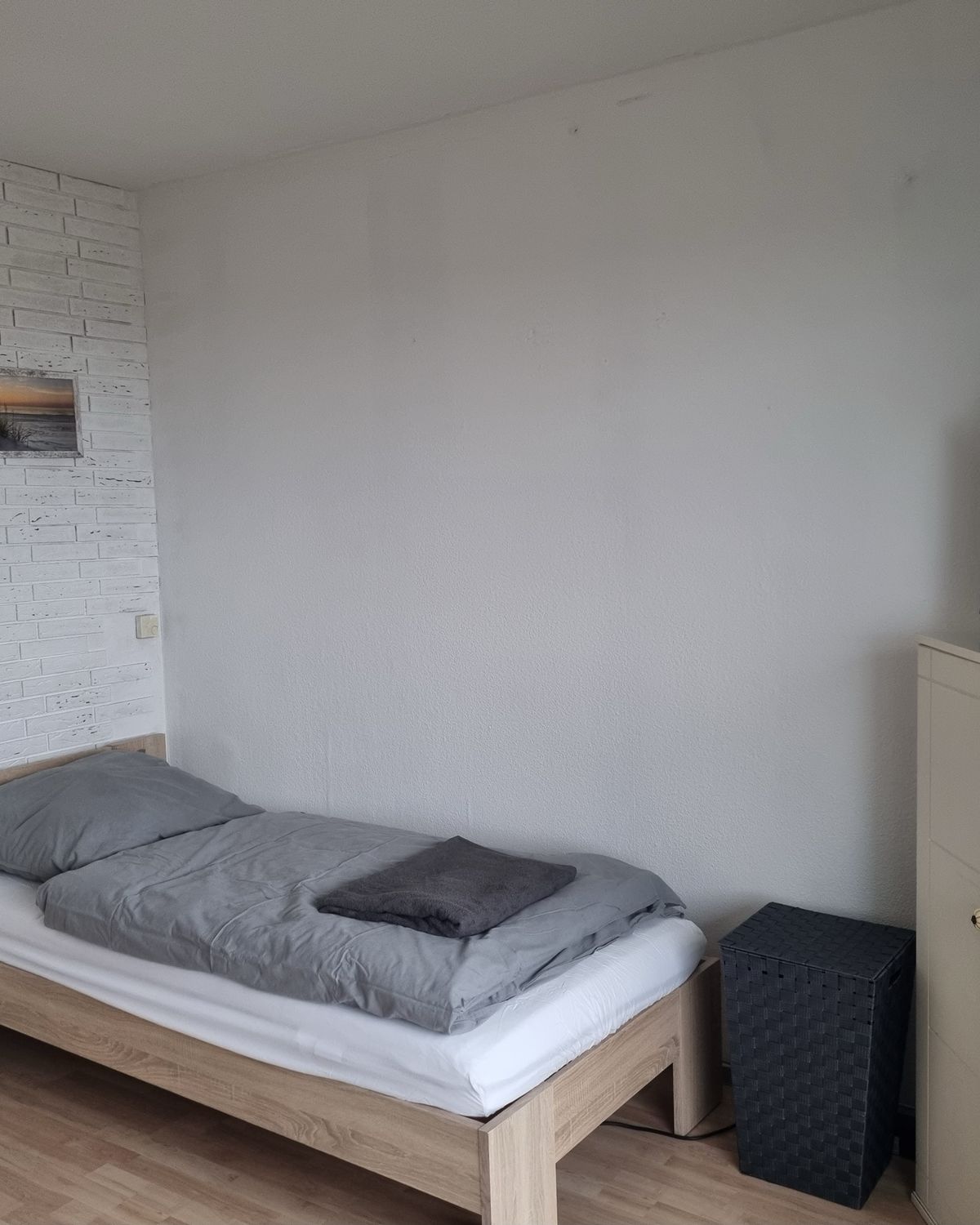 Einzelzimmer mit Bett, Fernseher und Kommode in einem möblierten MA-Flats Apartment